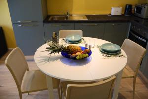 a white table with a bowl of fruit on it at Appartamento L'Aurora in Gabicce Mare