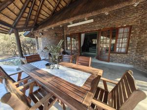 Una mesa y sillas de madera en un patio. en Noah's Ark, en Marloth Park