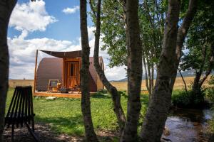 a small cabin in the middle of trees at RAZBIBRIGA - Riverside Camping Pod by IGLENA in Kupres