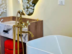 a bathroom with a gold faucet next to a toilet at Golden Era stylish studio i903 TenTon Zamalek in Cairo