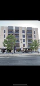 a large building with trees in front of a street at Söz suites in Al Khobar