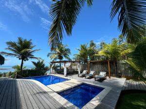 un cortile con piscina e terrazza in legno di Villa das cores a Porto Seguro
