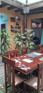 a wooden table and chairs in a room with plants at AylluWasi Guesthouse in Otavalo