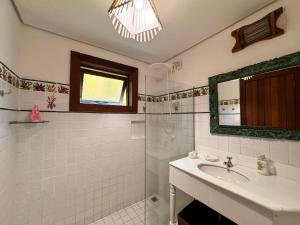 un bagno bianco con lavandino e specchio di Villa das cores a Porto Seguro Altre 9 foto