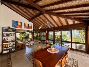 una sala da pranzo con tavolo e sedie in legno di Villa das cores a Porto Seguro