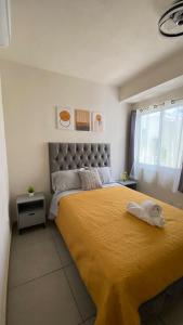 a bedroom with a large bed with a yellow bedspread at Casa Oasis Veracruzano in Veracruz