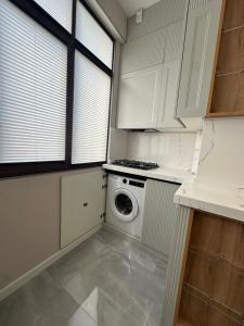 a white kitchen with a washer and dryer in it at Lux Apart Baku in Baku +2 photos