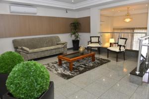 a living room with a couch and a table and chairs at Biazi Plaza Hotel in Bauru