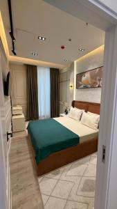 une chambre avec un grand lit avec une couverture verte dans l'établissement Nest One Tower, à Tachkent