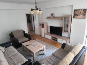 a living room with two couches and a television at TriKula Nest in Bar