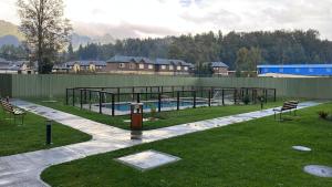 a swimming pool in a park with a building and a yard at Departamento Pucón 4 personas in Pucón