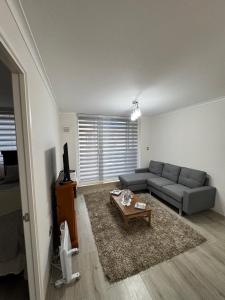 a living room with a couch and a coffee table at Departamento Pucón 4 personas in Pucón