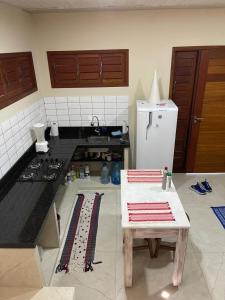 a kitchen with a stove and a table in it at Casa Barra do Camaratuba in Mataraca
