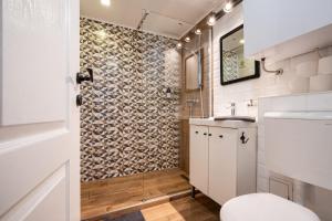 a bathroom with a toilet and a stone wall at Funhouse Dob in Budapest