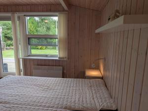 une chambre avec un lit et une fenêtre dans l'établissement Charming Cottage With Large Fenced Garden, à Løgstør