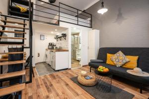 a living room with a black couch and a kitchen at Funhouse Dob in Budapest +34 photos