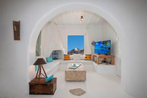 a white living room with a couch and a tv at The Aegean Residence Villa 6 Bedroom nearby the City in Kanalia Area by Hospirit in Mýkonos City