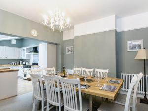 a dining room with a wooden table and white chairs at Frankland House in Whitby +19 photos