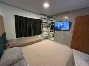 Μια τηλεόραση ή/και κέντρο ψυχαγωγίας στο Apartamento na Av das Cataratas de 02 quartos
