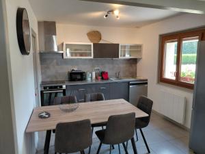 a kitchen with a wooden table and chairs at Maison La Pallud in Domancy