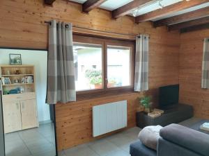 a living room with a couch and a window at Maison La Pallud in Domancy