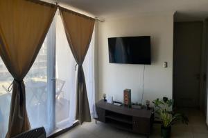 a living room with a flat screen tv and a window at VR | La Serena parking free vista al mar acceso directo a la playa, Puerta del Mar in La Serena