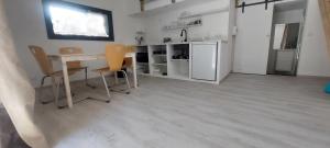 a kitchen with a table and chairs in a room at APPARTEMENT 4 PERSONNES 100 metres du Lac jardin privé in Doussard
