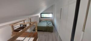 a small room with a bed and a staircase at APPARTEMENT 4 PERSONNES 100 metres du Lac jardin privé in Doussard
