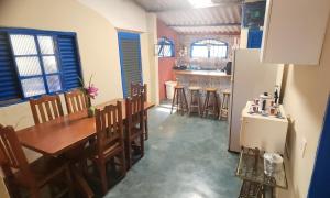 eine Küche und ein Esszimmer mit einem Tisch und einem Kühlschrank in der Unterkunft Recanto dos Maciotas in Alto Paraíso de Goiás + 13 Fotos