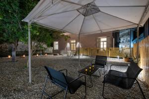a patio with chairs and a table under an umbrella at Alba Boutique Hotel in Chania Town