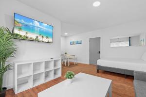 a living room with a bed and a tv on the wall at Harding Apartments by Andes STR in Miami Beach