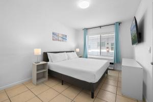 a bedroom with a bed and a tv and a window at Harding Apartments by Andes STR in Miami Beach