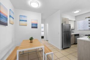 a kitchen with a table and a refrigerator at Harding Apartments by Andes STR in Miami Beach