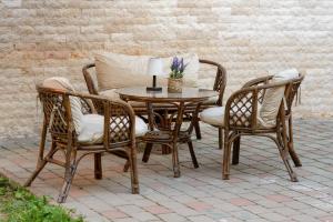 a wooden table with two chairs and a table with a lamp at Eden Central Boutique Suites - Garden & Spacious Apartments in Cluj-Napoca