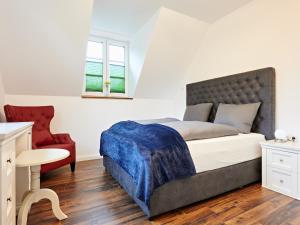 une chambre avec un lit et une chaise rouge dans l'établissement Villa in Wendorf nahe WINSTONgolf Platz, à Müsselmow