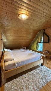 a bedroom with a bed in a wooden room at Vila Tea Durmitor in Žabljak