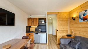una cucina e un soggiorno con divano e tavolo di Résidence Iris - Studio entièrement rénové avec cabine · Centre station · Balcon MAE-4504 a Magland