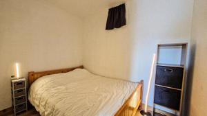 una piccola camera da letto con un letto e una cassettiera di Résidence Iris - Studio entièrement rénové avec cabine · Centre station · Balcon MAE-4504 a Magland