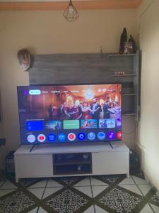 a flat screen tv sitting on top of a stand at Quarto triplo com banheiro em casa compartilhada COP 30 in Belém