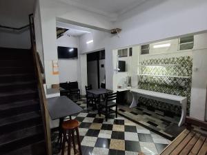 a room with a staircase and a table and chairs at Hotel Praça Orione in São Paulo