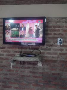 Un televisor de pantalla plana colgado en una pared de ladrillos en El gringo, en Victoria
