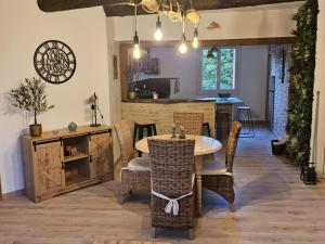 a dining room with a table and chairs and a kitchen at La Maison Delle Spellé - Meublé de Tourisme 4 étoiles in Piolenc