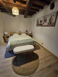 a bedroom with a bed with a ottoman in it at La Maison Delle Spellé in Piolenc
