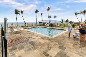 a group of people standing next to a swimming pool at Kihei Surfside 613 - MCH in Kihei