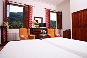 a bedroom with a bed and two chairs and a television at Agroturisme Finca Sa Maniga in Bunyola +49 photos