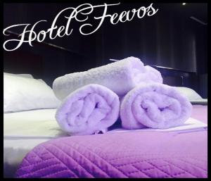 uma cama com toalhas roxas em cima em Feevos em Piraeus