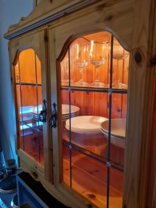 a wooden cabinet with wine glasses in it at Järnvägsgatan 28 in Sundbyberg