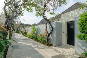 a walkway leading to a house with a black door at The Seminyak Suites Private Villas in Seminyak