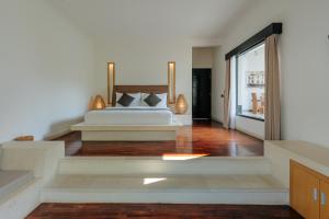 a bedroom with a bed and a sliding glass door at The Seminyak Suites Private Villas in Seminyak