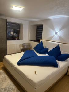 ein Schlafzimmer mit einem großen Bett mit blauen Kissen in der Unterkunft Ferienwohnung für Gruppen oder Familien in Schönwies